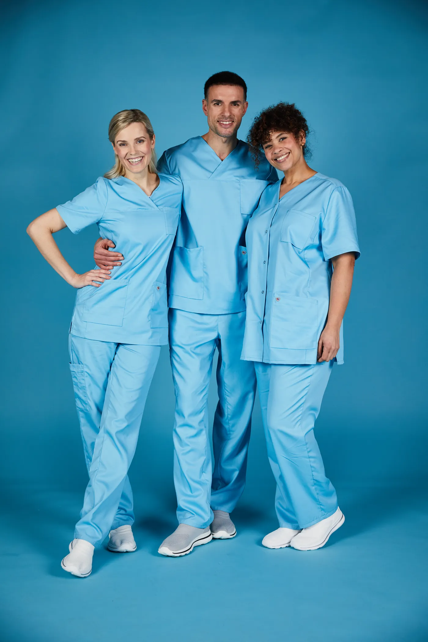Drei Models in BP-Kasack vor blauem Hintergrund