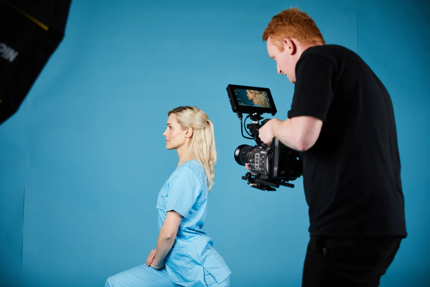 Videograf filmt ein sitzendes Model im Profil