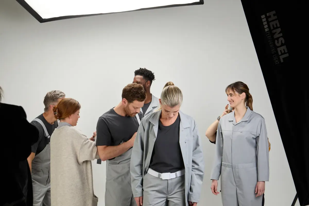 Stylistin richtet beim Making-of für BP Colors die Kleidung der Models