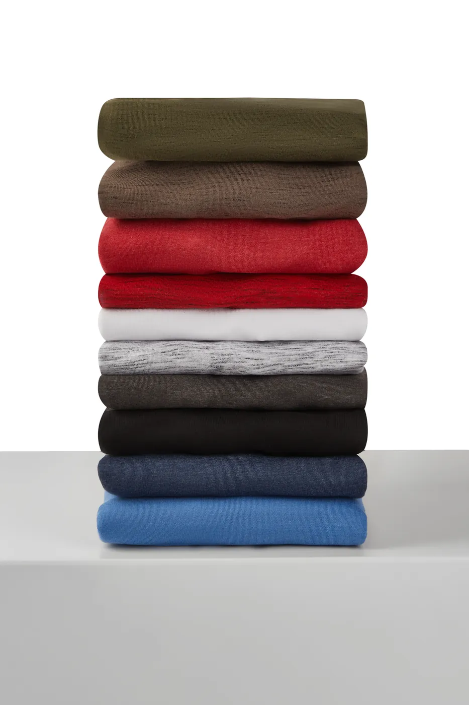 Produktfoto: Stapel gefalteter BP-Shirts in verschiedenen Farben auf einem weißen Podest