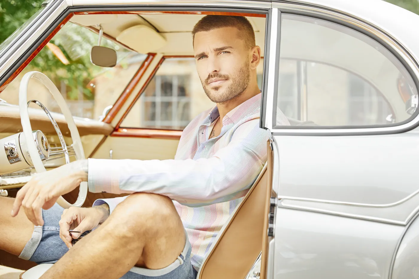 Model im gestreiften Hemd sitzt in einem Oldtimer, Fashion-Shooting für HAUPT