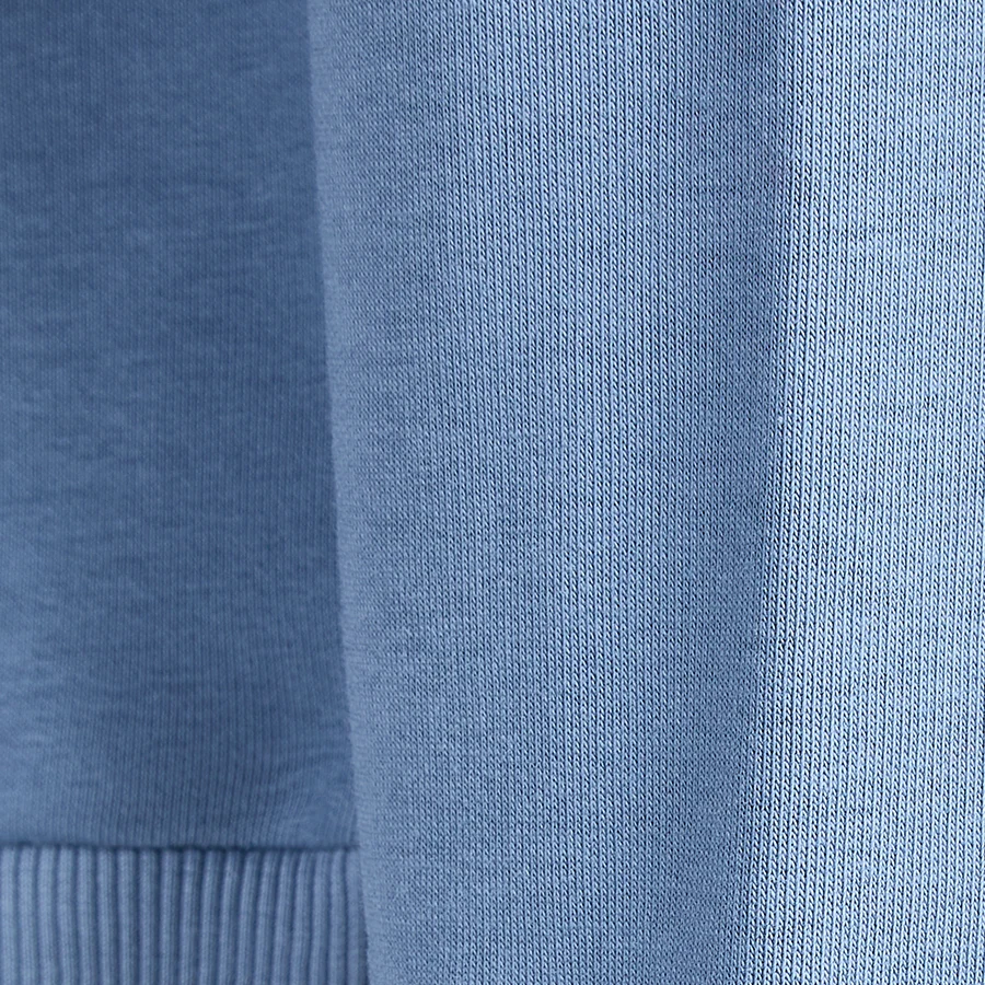 Fotografierte Nahaufnahme des echten Sweatshirts mit sichtbarer Stoffstruktur und geripptem Bündchen
