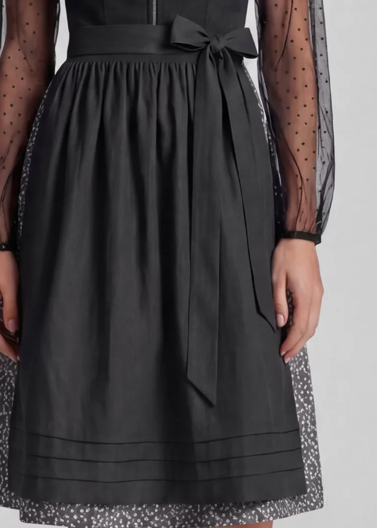 Detailaufnahme am KI-Model: schwarze Schürze mit Biesen über dem gemusterten Rock